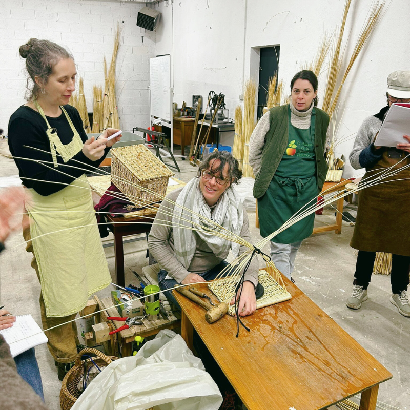 Karelle en démoonstration de tissage d'osier, souriant à la caméra