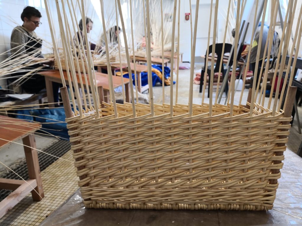 salle de l'atelier de vannerie au travers d'un panier - CAP VANNERIE LE VERGER